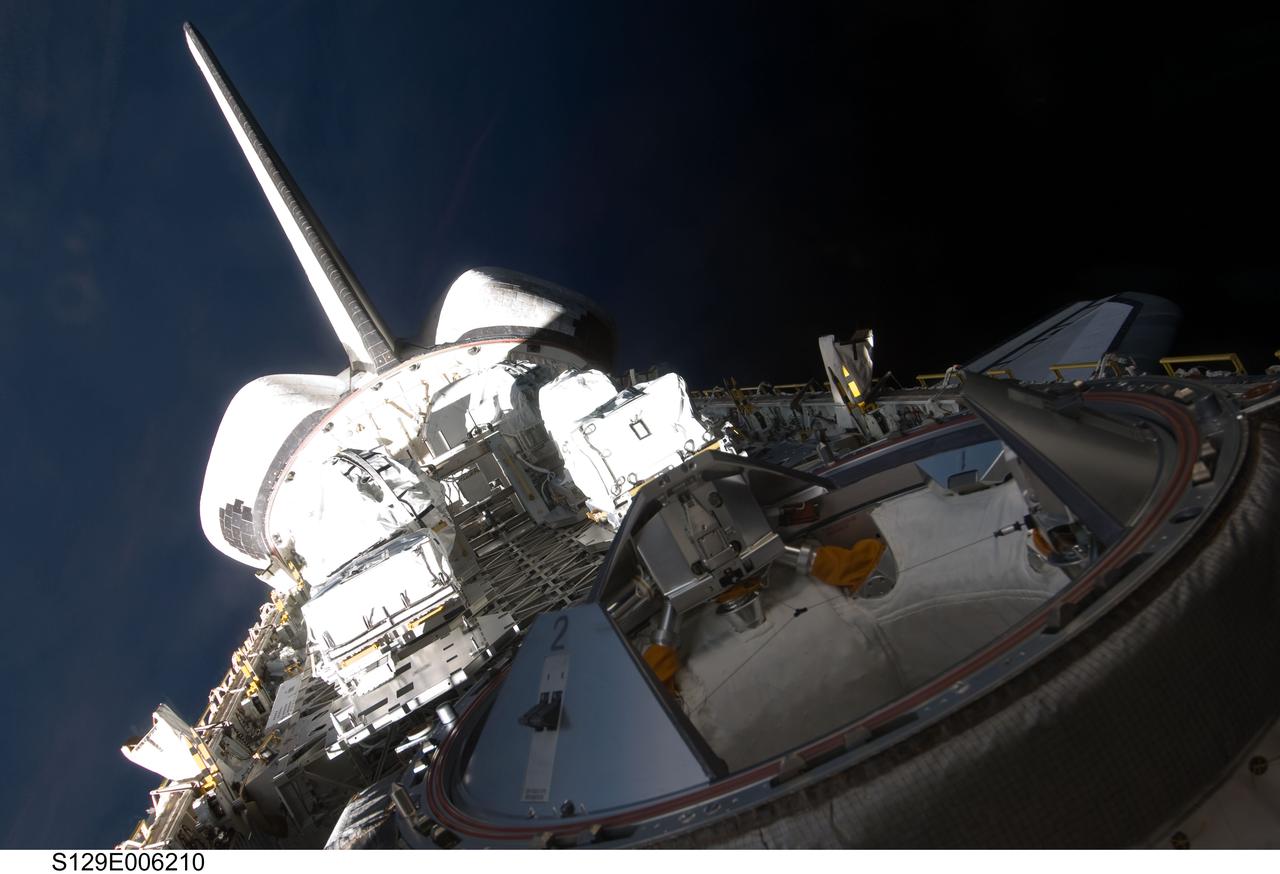 S129-E-006210 (17 Nov. 2009) --- Backdropped by the blackness of space, a partial view of Space Shuttle Atlantis? payload bay, vertical stabilizer, orbital maneuvering system (OMS) pods and docking mechanism are featured in this image photographed by an STS-129 crew member from an aft flight deck window.