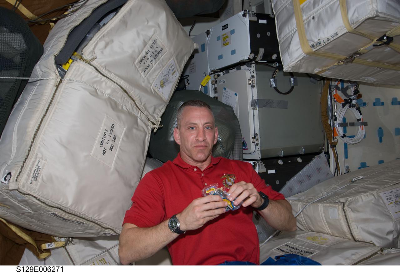 S129-E-006271 (17 Nov. 2009) --- Astronaut Charles O. Hobaugh, STS-129 commander, eats a snack on the middeck of Space Shuttle Atlantis during flight day two activities.