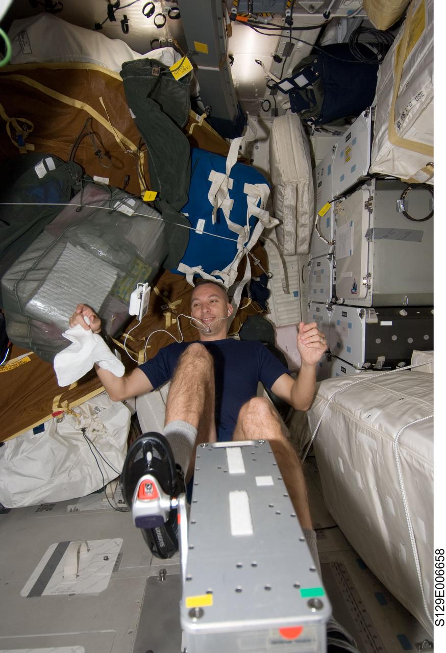 S129-E-006658 (18 Nov. 2009) --- Astronaut Randy Bresnik, STS-129 mission specialist, exercises on a bicycle ergometer on the middeck of Space Shuttle Atlantis during flight day three activities.