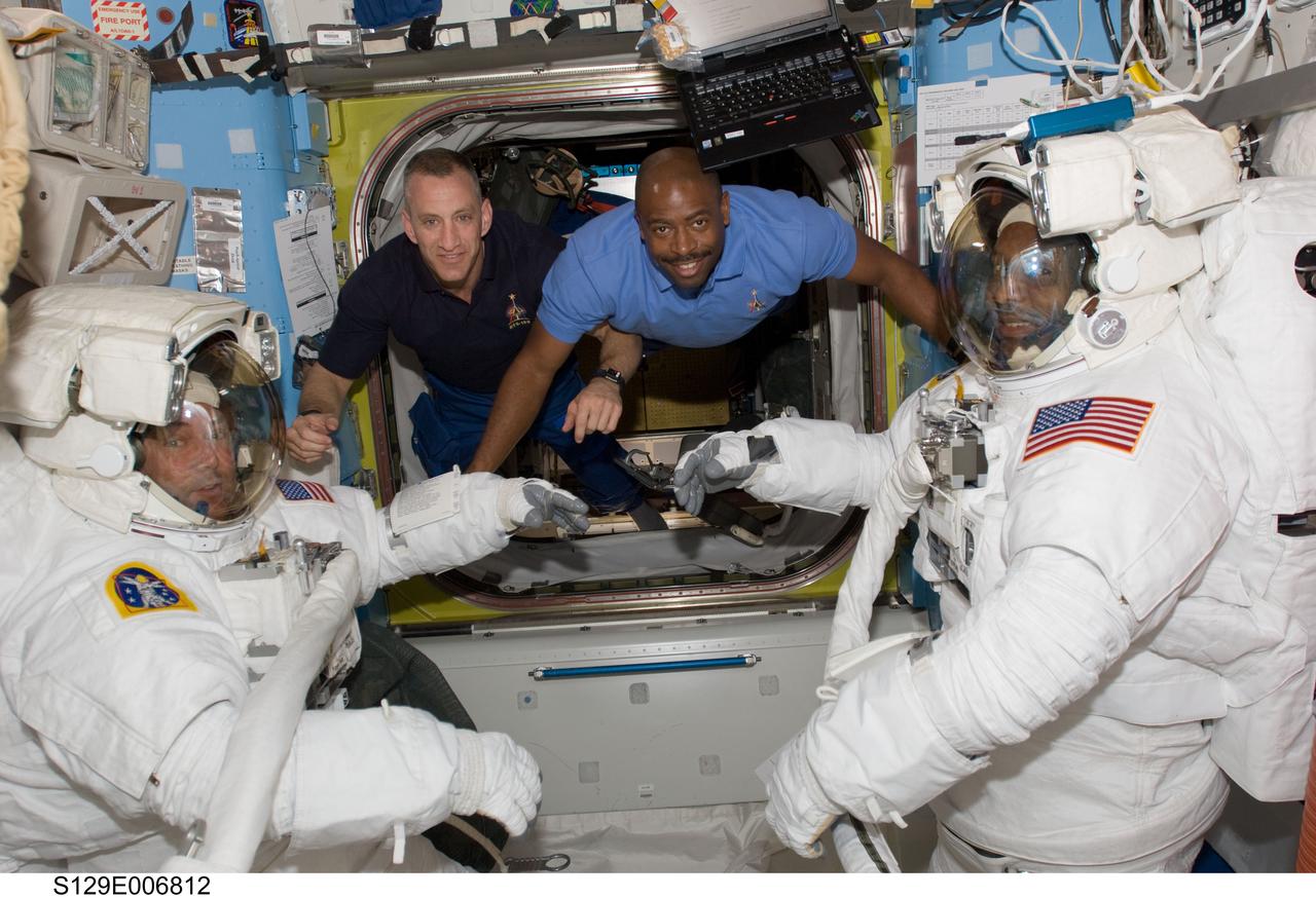 S129-E-006812 (19 Nov. 2009) --- In the Quest airlock, astronauts  Mike Foreman (left) and  Robert L. Satcher Jr.  (right), STS-129 mission specialists,  get ready for their flight day four space walk, as astronauts Charles O. Hobaugh (second left), commander, and Leland Melvin, mission specialist, stay close at hand to assist them.
