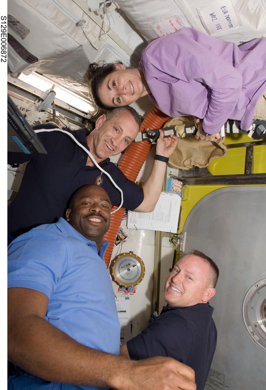 S129-E-006872 (19 Nov. 2009) --- Astronauts Charles O. Hobaugh (top left), STS-129 commander; Barry E. Wilmore (bottom right), pilot; Leland Melvin and Nicole Stott, both mission specialists, pose for a photo in the Quest airlock of the International Space Station after closing the hatch to begin the mission?s first spacewalk.