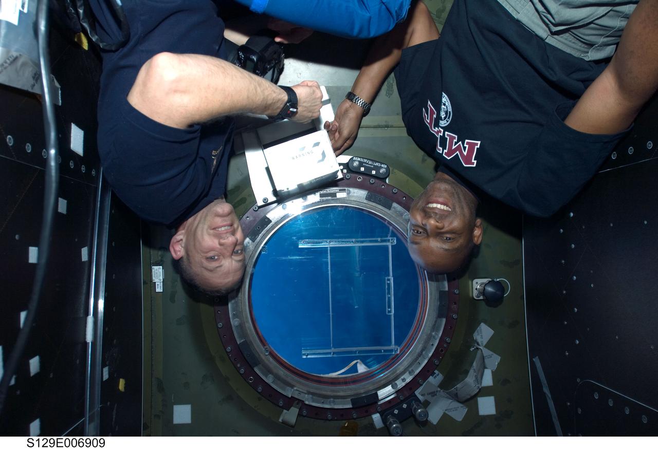 S129-E-006909 (20 Nov. 2009) --- Astronauts Charles O. Hobaugh (left), STS-129 commander; and Robert L. Satcher Jr., mission specialist, are pictured near a window in the Destiny laboratory of the International Space Station while Space Shuttle Atlantis remains docked with the station.