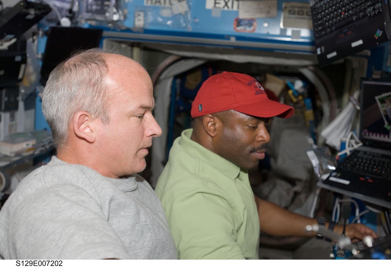 S129-E-007202 (21 Nov. 2009) --- NASA astronauts Jeffrey Williams (left), Expedition 21 flight engineer, and Leland Melvin, STS-129 mission specialist, support the extravehicular activity of astronauts Mike Foreman and Randy Bresnik from the shirt sleeve environment of the International Space Station.  While Foreman and Bresnik worked outside, an aggregation of ten internationally-represented astronauts and cosmonauts worked onboard both the space shuttle Atlantis and the International Space Station to support their tasks.