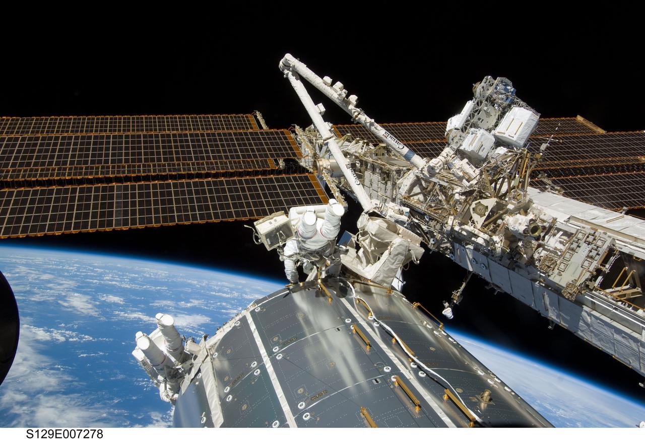S129-E-007278 (21 Nov. 2009) --- Backdropped against the horizon of Earth, astronauts Mike Foreman (center frame) and Randy Bresnik, STS-129 mission specialists, perform a series of tasks on the exterior of the International Space Station during the second space walk of Atlantis’ visit to the orbital outpost