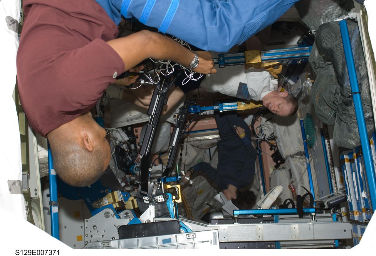 S129-E-007371 (22 Nov. 2009) --- In the Unity Node aboard the International Space Station, European Space Agency astronaut Frank De Winne, Expedition 21 commander, works out on the advanced Resistive Exercise Device, or aRED for short, which functions like a weight machine in a gym. Astronauts Nicole Stott and Robert L. Satcher Jr., STS-129 mission specialists, are also pictured.