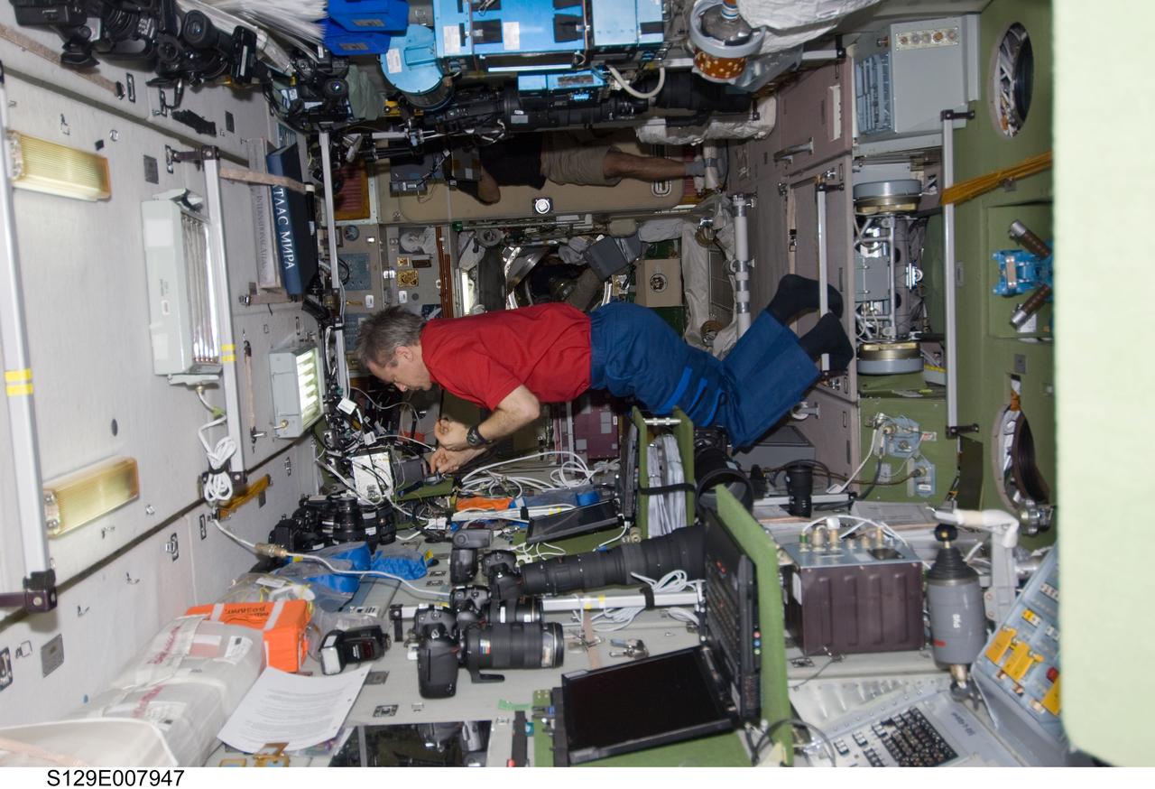 S129-E-007947 (23 Nov. 2009) --- Canadian Space Agency astronaut Robert Thirsk, Expedition 21 flight engineer, works in the Zvezda Service Module of the International Space Station while space shuttle Atlantis (STS-129) remains docked with the station.