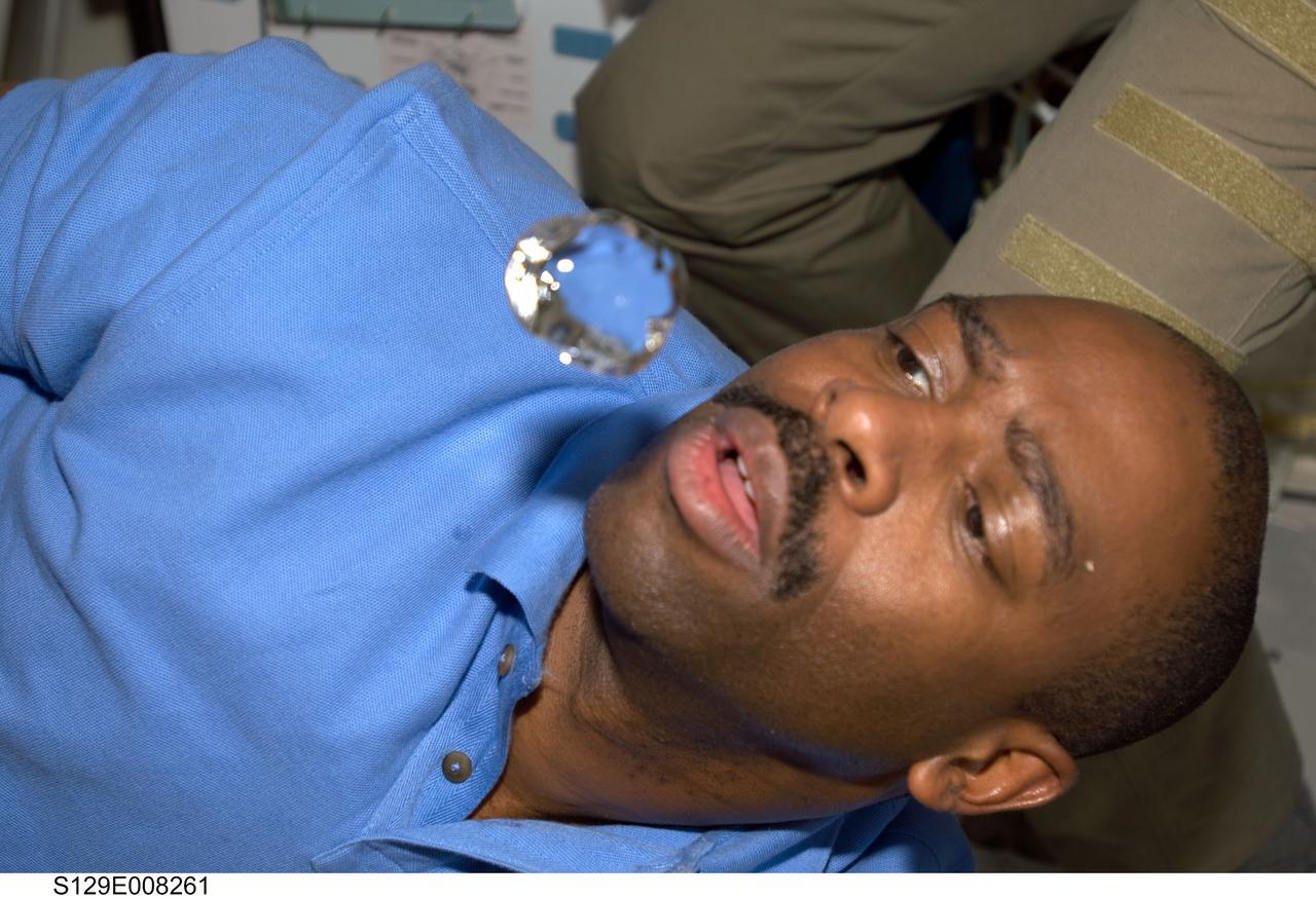 S129-E-008261 (24 Nov. 2009) --- Astronaut Leland Melvin, STS-129 mission specialist, watches a bubble float freely, after having squeezed it from his beverage container, on the middeck of space shuttle Atlantis.