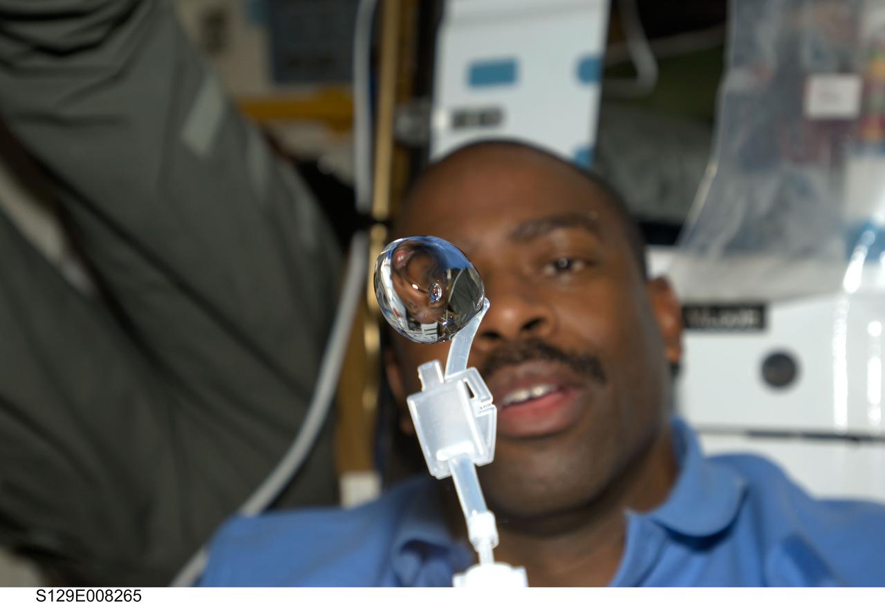 S129-E-008265 (24 Nov. 2009) --- Astronaut Leland Melvin, STS-129 mission specialist, watches a bubble float freely, after having squeezed it from his beverage container, on the middeck of space shuttle Atlantis.