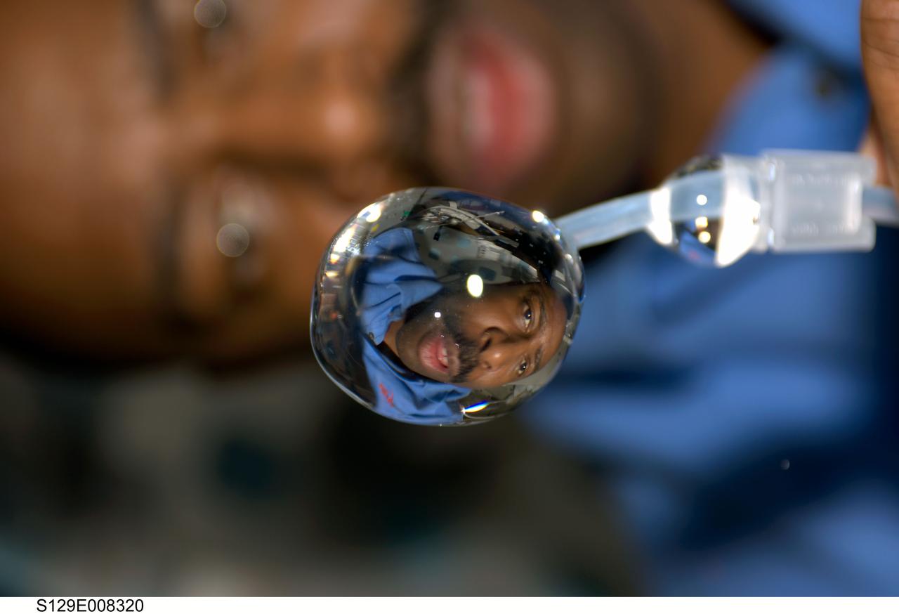 S129-E-008320 (24 Nov. 2009) --- This close-up view of a water bubble floating freely on the middeck of space shuttle Atlantis shows a refracted image of astronaut Leland Melvin, STS-129 mission specialist.