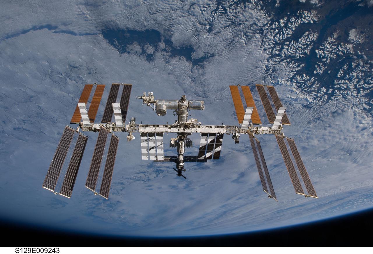 S129-E-009243 (25 Nov. 2009) --- Set against the background of a cloud covered Earth, the International Space Station is featured in this image photographed by an STS-129 crew member on Atlantis soon after the station and shuttle began their post-undocking relative separation. Undocking of the two spacecraft occurred at 3:53 a.m. (CST) on Nov. 25, 2009.