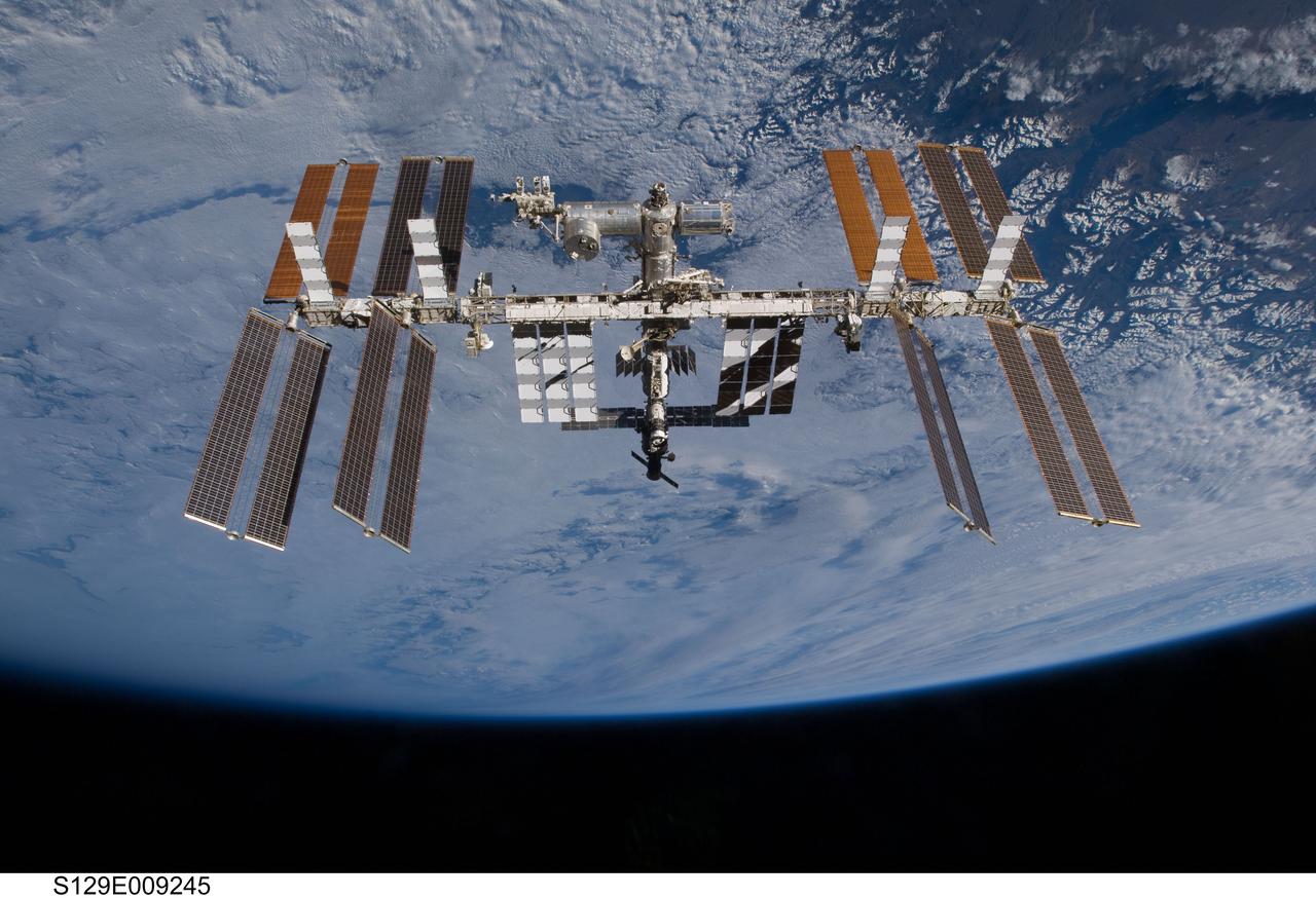 S129-E-009245 (25 Nov. 2009) --- Set against a background of clouds, the International Space Station is featured in this image photographed by an STS-129 crew member on Atlantis soon after the station and shuttle began their post-undocking relative separation. Undocking of the two spacecraft occurred at 3:53 a.m. (CST) on Nov. 25, 2009.