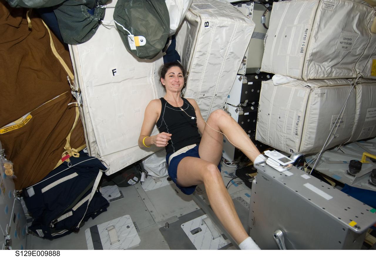 S129-E-009888 (25 Nov. 2009) --- Astronaut Nicole Stott, STS-129 mission specialist, gets in a workout on the bicycle ergometer onboard the Earth-orbiting space shuttle Atlantis during flight day 10 activities.