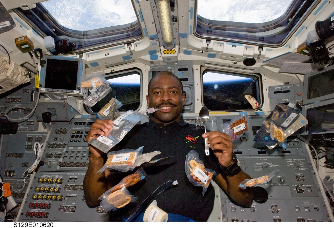 View of Mission Specialist 1 (MS1) Leland Melvin posing for a photo on the shuttle Atlantis Flight Deck (FD).  Drink and food packets float around him.  Photo taken during the STS-129 return flight home.