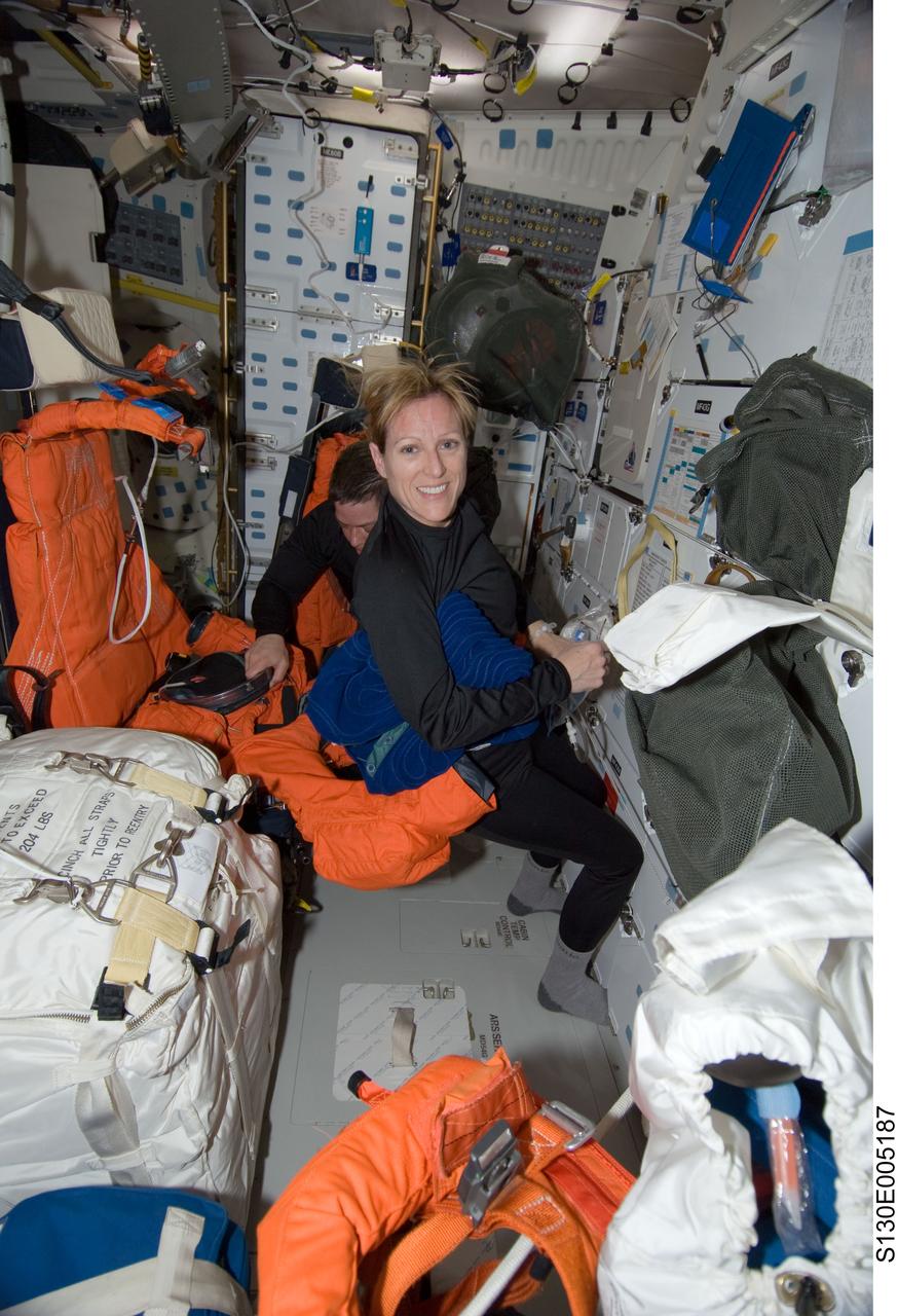 S130-E-005187 (8 Feb. 2010) --- NASA astronauts Kathryn Hire and Robert Behnken (mostly obscured), both STS-130 mission specialists, work on the middeck of space shuttle Endeavour during postlaunch activities.