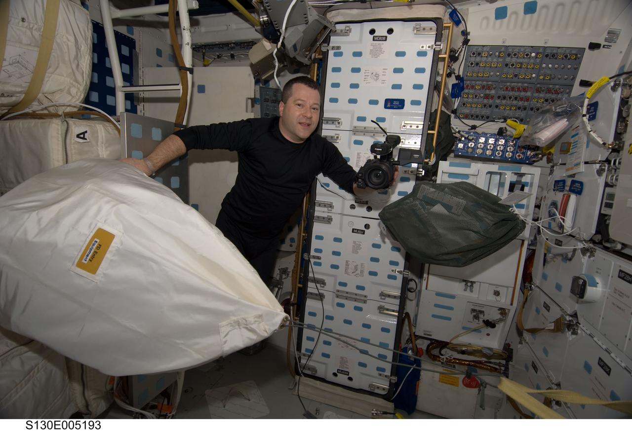 S130-E-005193 (8 Feb. 2010) --- NASA astronaut Nicholas Patrick, STS-130 mission specialist, is pictured holding a High Definition Video (HDV) camera on the middeck of space shuttle Endeavour during flight day one activities.