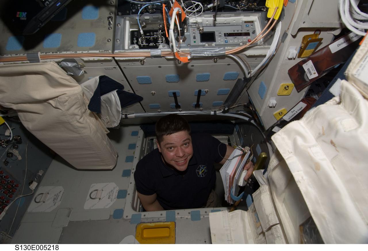 S130-E-005218 (8 Feb. 2010) --- NASA astronaut Robert Behnken, STS-130 mission specialist, smiles for the camera while in the hatch which connects the flight deck and middeck of space shuttle Endeavour during flight day one activities.