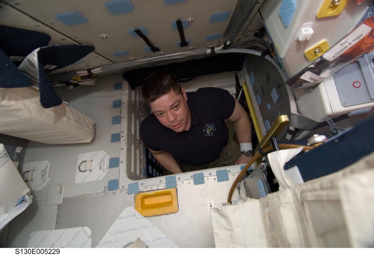 S130-E-005229 (8 Feb. 2010) --- NASA astronaut Robert Behnken, STS-130 mission specialist, is pictured in the hatch which connects the flight deck and middeck of space shuttle Endeavour during flight day one activities.