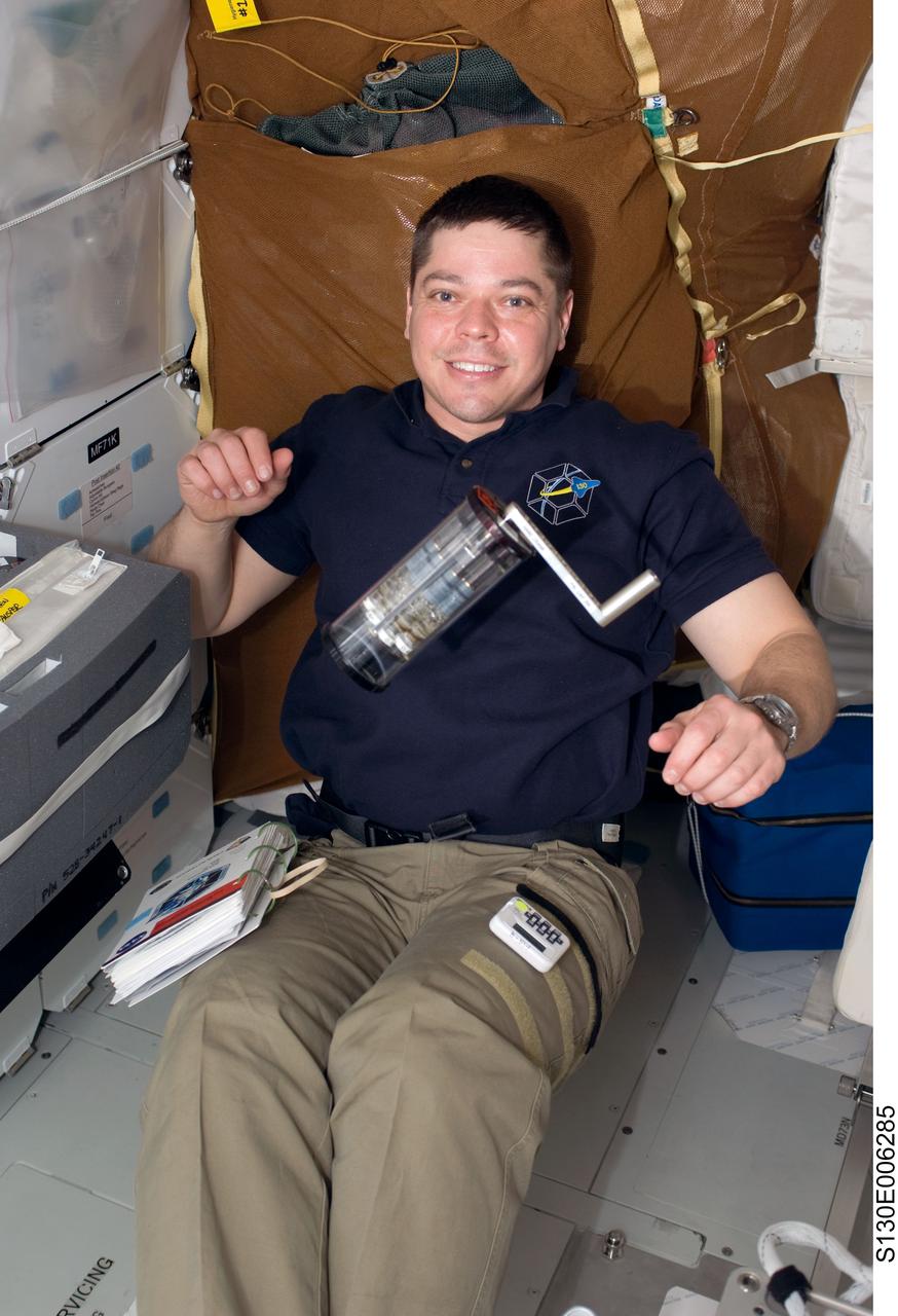 S130-E-006285 (9 Feb. 2010) --- Astronaut Robert Behnken, STS-130 mission specialist, works with a Fluid Processing Apparatus, which is part of the Microbe Group Activation Pack, on the middeck of space shuttle Endeavour during flight day two activities.