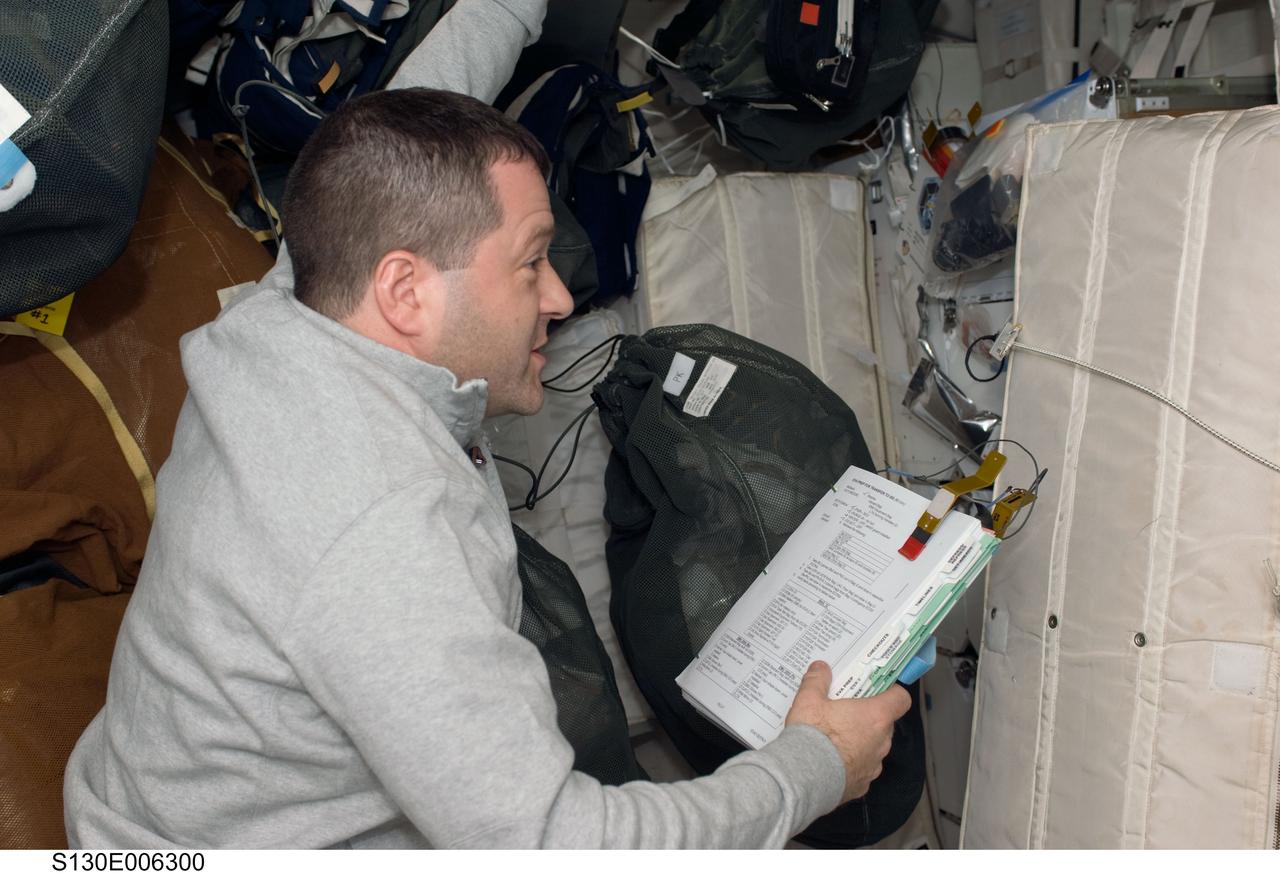 S130-E-006300 (9 Feb. 2010) --- Astronaut Nicholas Patrick, STS-130 mission specialist, checks equipment and supplies on the middeck of the Earth-orbiting space shuttle Endeavour during the early hours of flight day two.