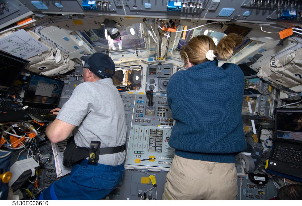 S130-E-006610 (9 Feb. 2010) --- NASA astronauts Stephen Robinson and Kathryn Hire, both STS-130 mission specialists, work on the aft flight deck of space shuttle Endeavour during flight day two activities.