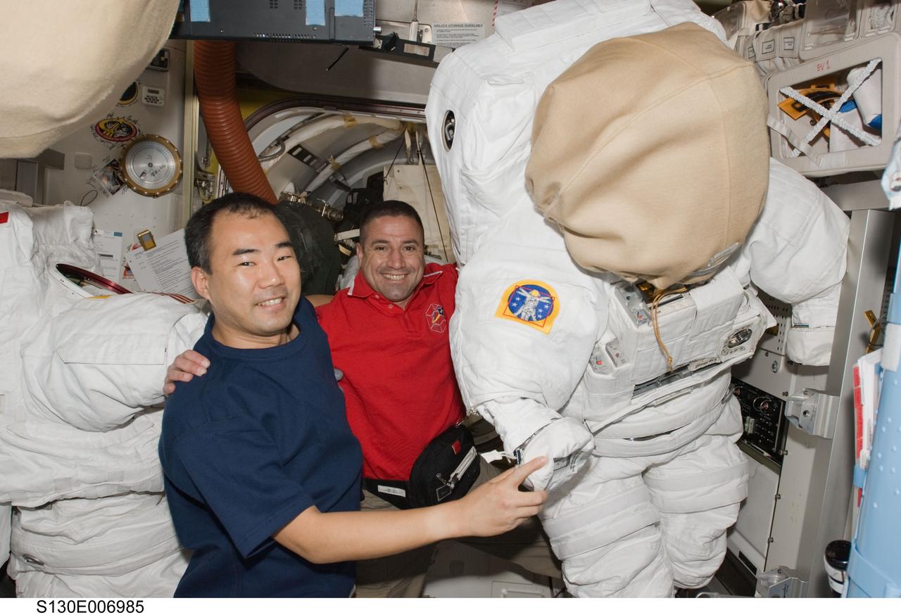 S130-E-006985 (10 Feb. 2010) --- Japan Aerospace Exploration Agency (JAXA) astronaut Soichi Noguchi (left), Expedition 22 flight engineer; and NASA astronaut George Zamka, STS-130 commander, are pictured with two Extravehicular Mobility Unit (EMU) spacesuits in the Quest airlock of the International Space Station while space shuttle Endeavour remains docked with the station.