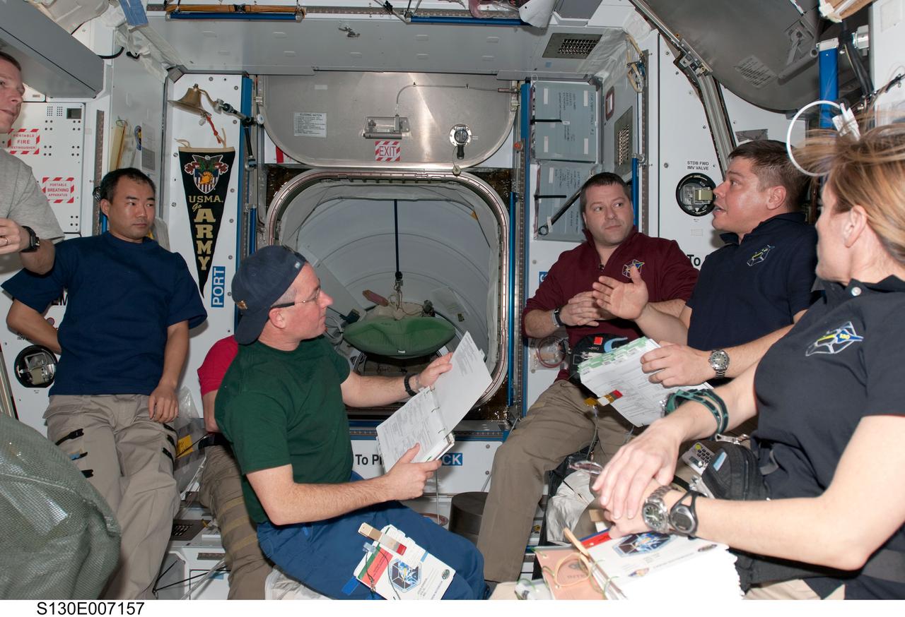 S130-E-007157 (11 Feb. 2010) --- Shuttle and station crew members work in the Harmony node of the International Space Station while space shuttle Endeavour remains docked with the station. Pictured from the left are NASA astronaut Terry Virts (mostly out of frame), STS-130 pilot; Japan Aerospace Exploration Agency (JAXA) astronaut Soichi Noguchi, Expedition 22 flight engineer; and NASA astronauts Stephen Robinson, Nicholas Patrick, Robert Behnken and Kathryn Hire, all STS-130 mission specialists.