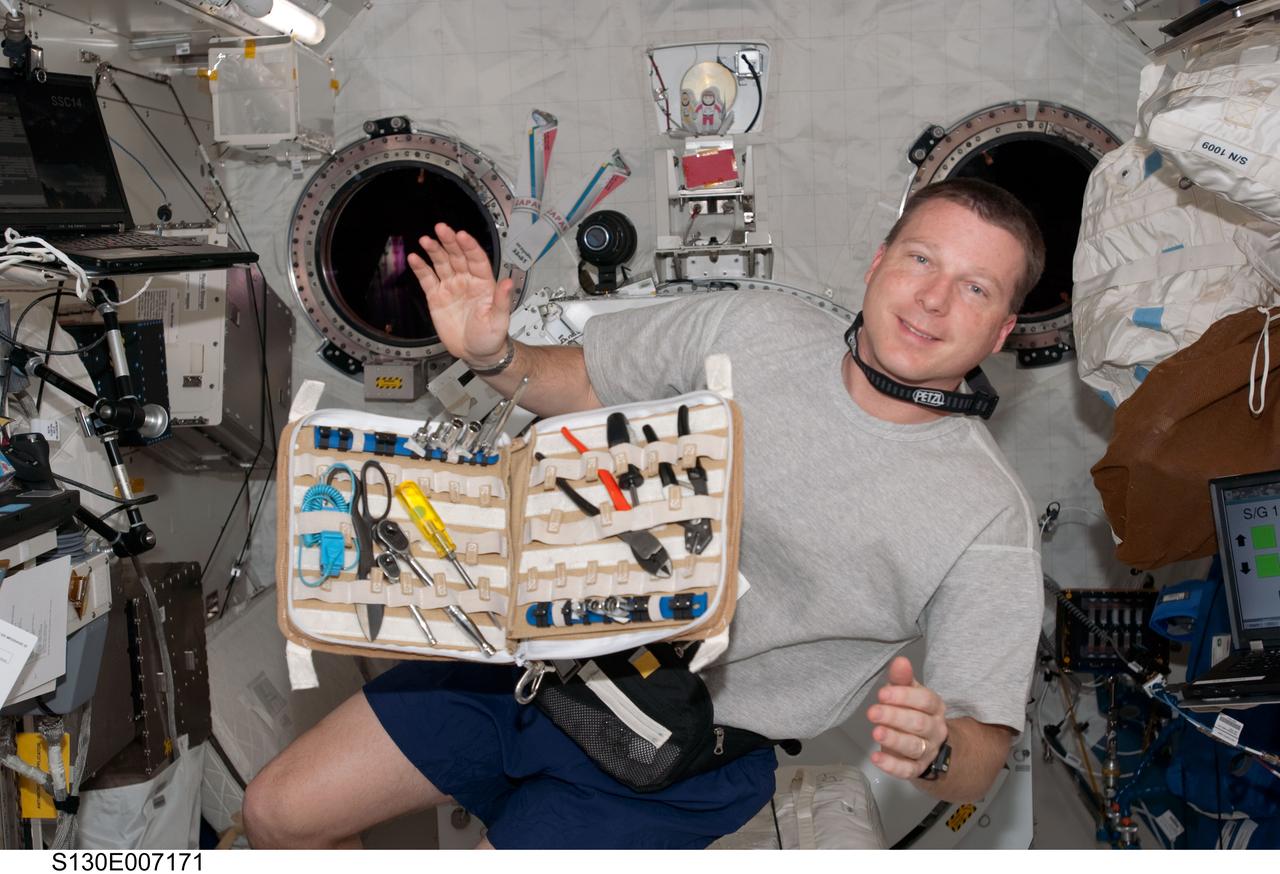 S130-E-007171 (11 Feb. 2010) --- NASA astronaut Terry Virts, STS-130 pilot, poses for a photo near a container of tools floating freely in the Kibo laboratory of the International Space Station while space shuttle Endeavour remains docked with the station.