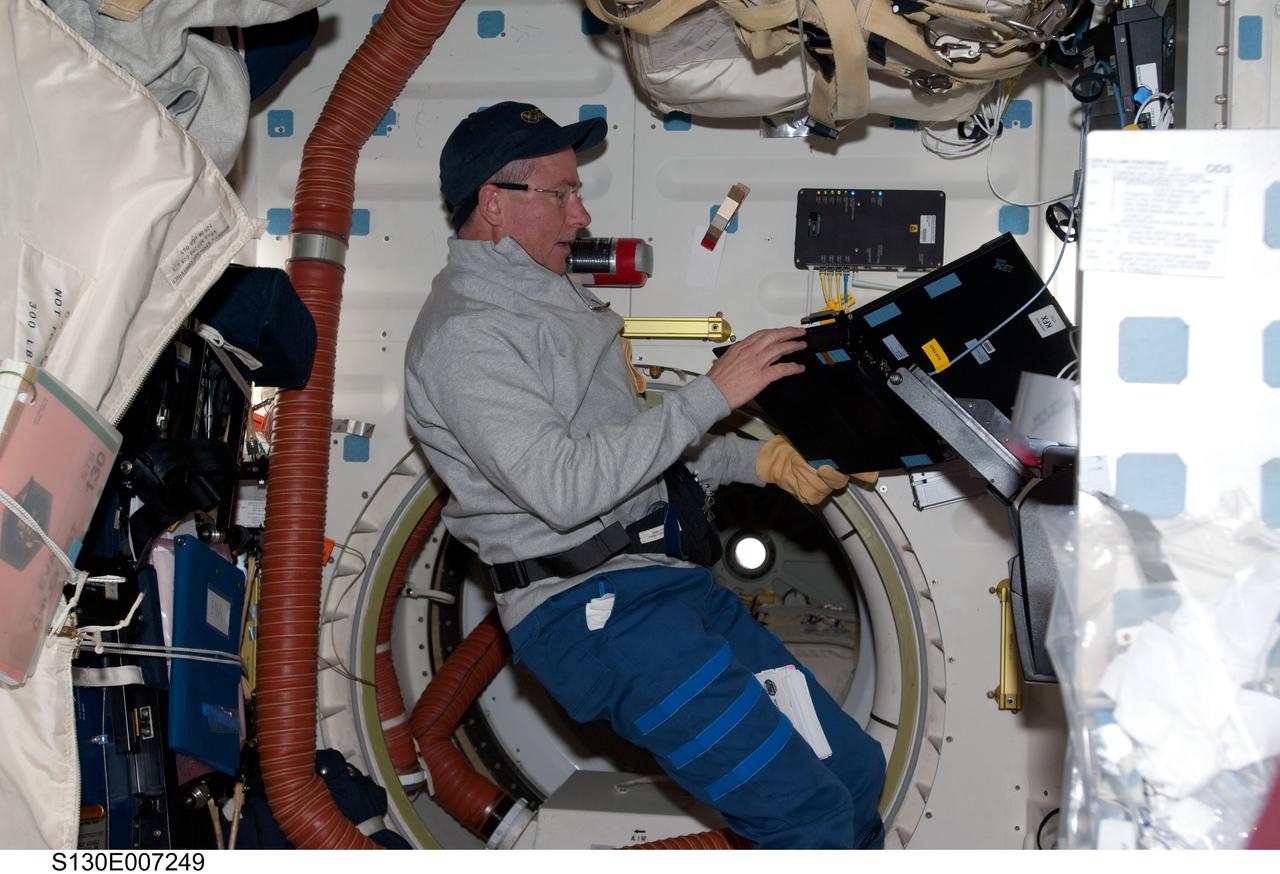 S130-E-007249 (11 Feb. 2010) --- NASA astronaut Stephen Robinson, STS-130 mission specialist, uses a computer on the middeck of space shuttle Endeavour while docked with the International Space Station.