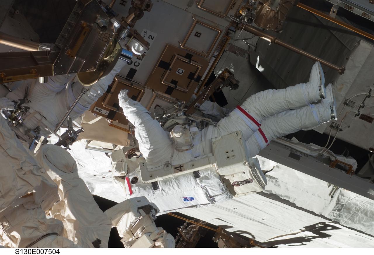 S130-E-007504 (11 Feb. 2010) --- NASA astronauts Robert Behnken and Nicholas Patrick (partially obscured at left), both STS-130 mission specialists, participate in the mission's first session of extravehicular activity (EVA) as construction and maintenance continue on the International Space Station. During the 6-hour, 32-minute spacewalk, Behnken and Patrick relocated a temporary platform from the Special Purpose Dexterous Manipulator, or Dextre, to the station’s truss structure and installed two handles on the robot. Once Tranquility was structurally mated to Unity, the spacewalkers connected heater and data cables that will integrate the new module with the rest of the station’s systems. They also pre-positioned insulation blankets and ammonia hoses that will be used to connect Tranquility to the station’s cooling radiators during the mission’s second spacewalk.