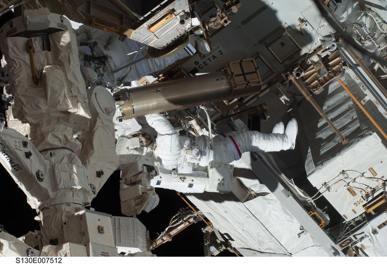 S130-E-007512 (11 Feb. 2010) --- NASA astronauts Robert Behnken and Nicholas Patrick (partially obscured at top left), both STS-130 mission specialists, participate in the mission's first session of extravehicular activity (EVA) as construction and maintenance continue on the International Space Station. During the 6-hour, 32-minute spacewalk, Behnken and Patrick relocated a temporary platform from the Special Purpose Dexterous Manipulator, or Dextre, to the station’s truss structure and installed two handles on the robot. Once Tranquility was structurally mated to Unity, the spacewalkers connected heater and data cables that will integrate the new module with the rest of the station’s systems. They also pre-positioned insulation blankets and ammonia hoses that will be used to connect Tranquility to the station’s cooling radiators during the mission’s second spacewalk.