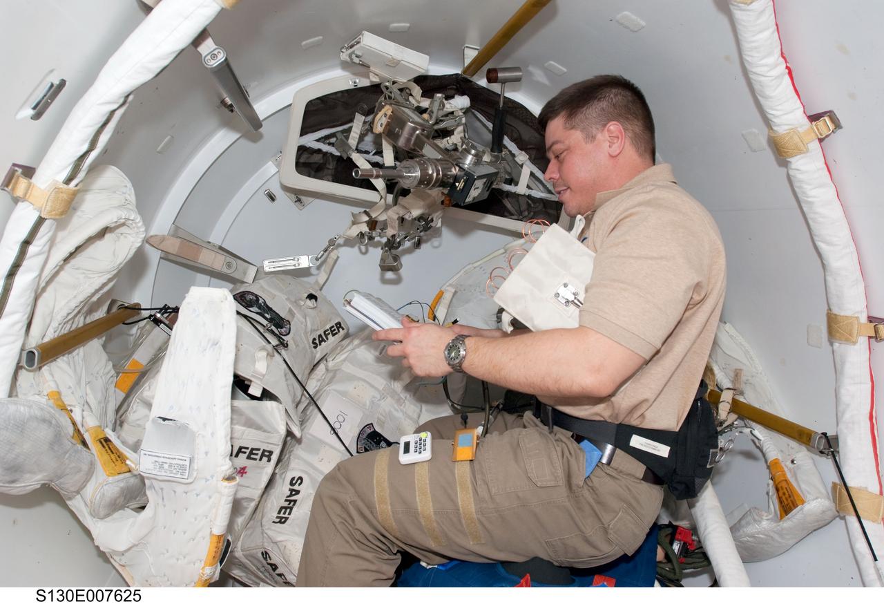 S130-E-007625 (13 Feb. 2010) --- NASA astronaut Robert Behnken, STS-130 mission specialist, works in the Quest airlock of the International Space Station while space shuttle Endeavour remains docked with the station.