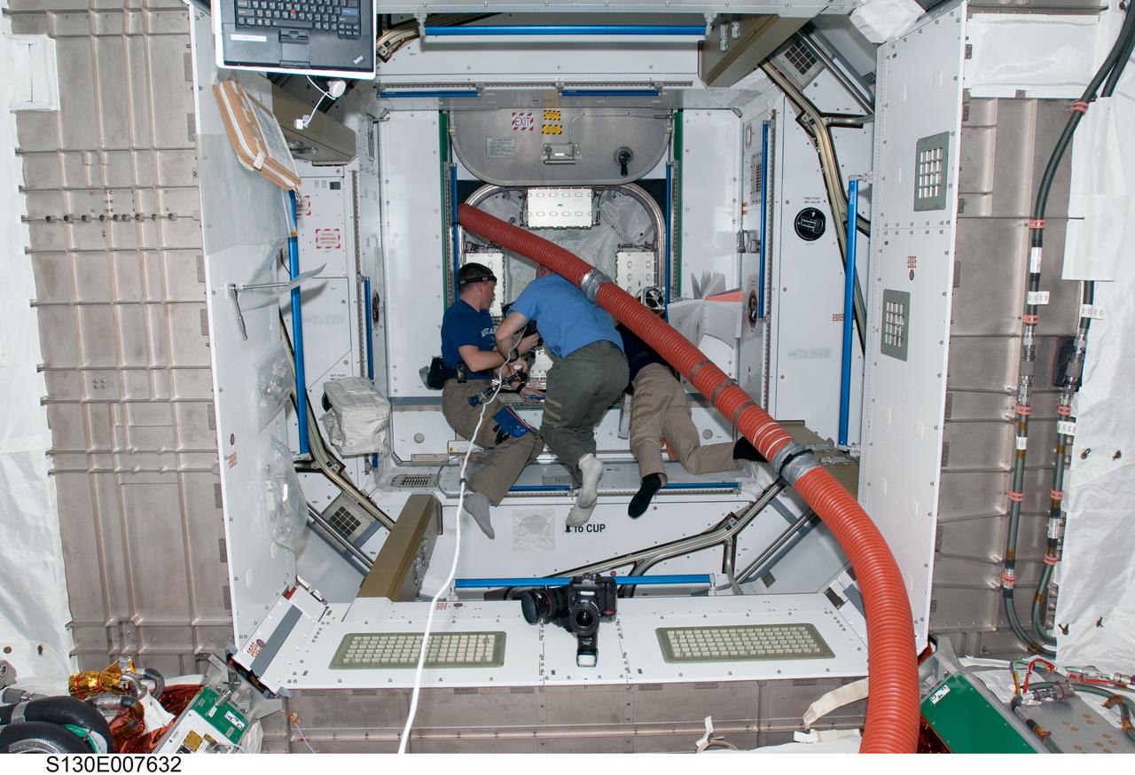 S130-E-007632 (13 Feb. 2010) --- NASA astronauts Jeffrey Williams (center), Expedition 22 commander; Terry Virts (left), STS-130 pilot; and Nicholas Patrick, STS-130 mission specialist, work in the newly-installed Tranquility node of the International Space Station while space shuttle Endeavour remains docked with the station.