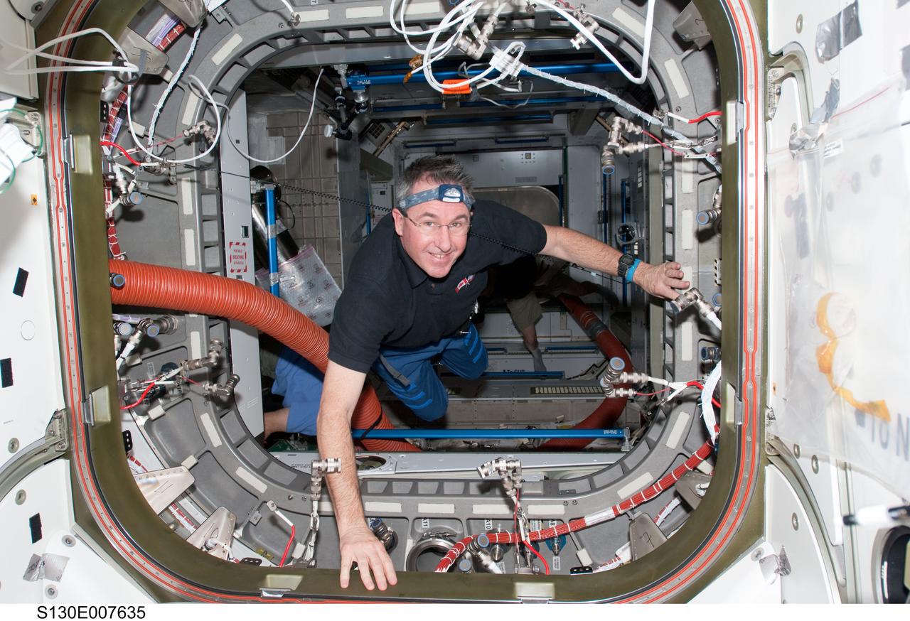S130-E-007635 (13 Feb. 2010) --- NASA astronaut Stephen Robinson, STS-130 mission specialist, works in the vestibule between the Unity node and the newly-installed Tranquility node of the International Space Station while space shuttle Endeavour remains docked with the station.