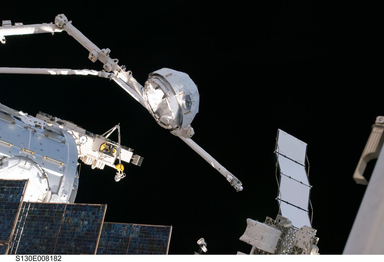 S130-E-008182 (15 Feb. 2010) --- In the grasp of the Canadarm2, the Cupola is relocated from the forward port to the Earth-facing port of the International Space Station’s newly-installed Tranquility node. NASA astronauts Terry Virts, STS-130 pilot; and Kathryn Hire, mission specialist, moved the Cupola, operating the station’s robotic arm from controls inside the Destiny laboratory.