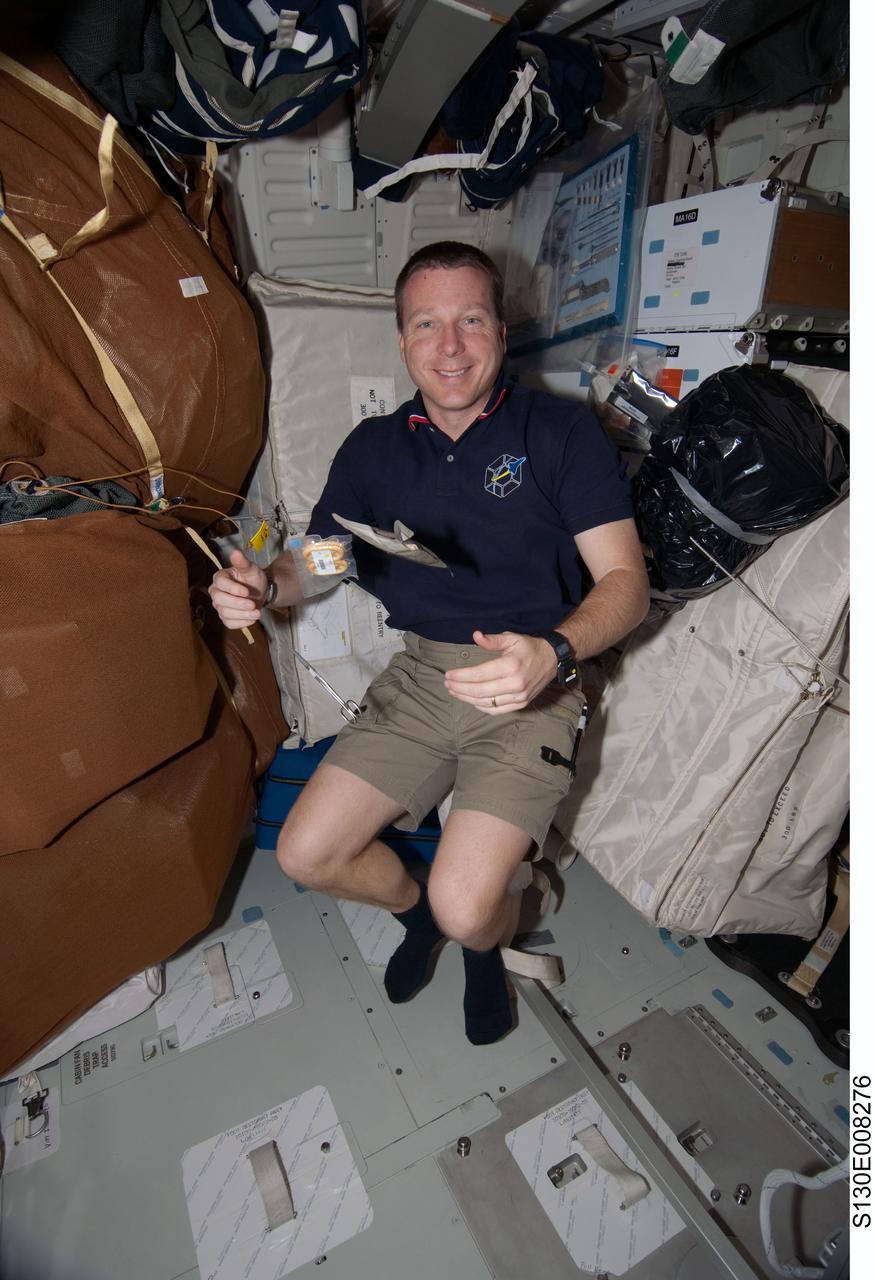 S130-E-008276 (15 Feb. 2010) --- NASA astronaut Terry Virts, STS-130 pilot, is pictured near food packages and scissors floating freely on the middeck of space shuttle Endeavour while docked with the International Space Station.