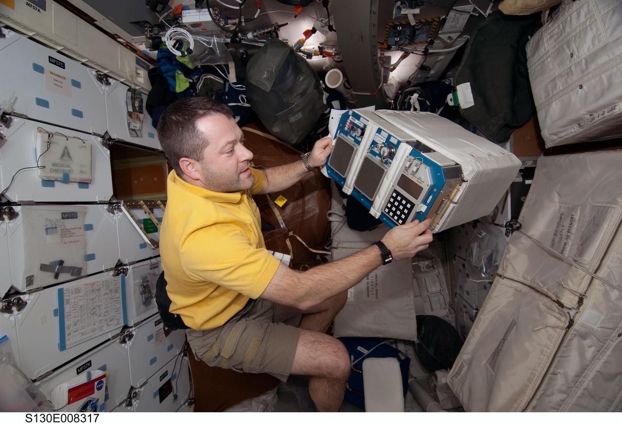 S130-E-008317 (15 Feb. 2010) --- NASA astronaut Nicholas Patrick, STS-130 mission specialist, works with equipment on the middeck of space shuttle Endeavour while docked with the International Space Station.