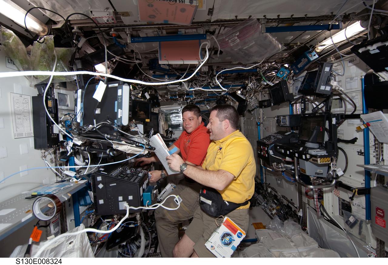 S130-E-008324 (15 Feb. 2010) --- NASA astronauts Nicholas Patrick (foreground) and Robert Behnken, both STS-130 mission specialists, work at a robotic workstation in the Destiny laboratory of the International Space Station while space shuttle Endeavour remains docked with the station.