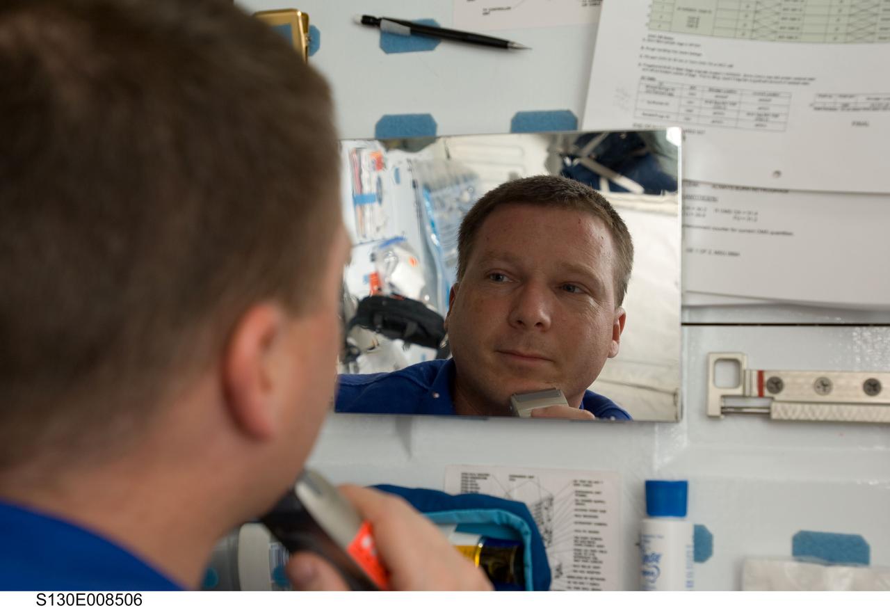 S130-E-008506 (15 Feb. 2010) --- NASA astronaut Terry Virts, STS-130 pilot, shaves his face at a mirror on the middeck of the space shuttle Endeavour while docked with the International Space Station.