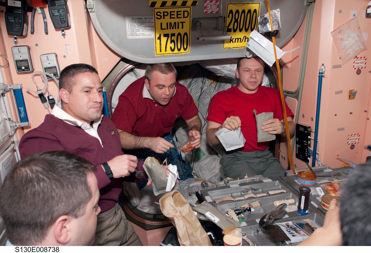 S130-E-008738 (15 Feb. 2010) --- STS-130 and Expedition 22 crew members share a meal in the Unity node of the International Space Station while space shuttle Endeavour remains docked with the station. Pictured from the left are NASA astronauts Nicholas Patrick, STS-130 mission specialist; George Zamka, STS-130 commander; along with Russian cosmonauts Maxim Suraev and Oleg Kotov, both Expedition 22 flight engineers.