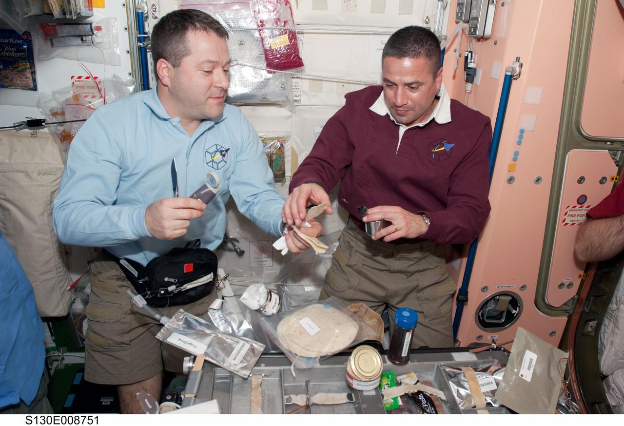 S130-E-008751 (15 Feb. 2010) --- STS-130 and Expedition 22 crew members share a meal in the Unity node of the International Space Station while space shuttle Endeavour remains docked with the station. Pictured from the right are George Zamka, STS-130 commander; and Nicholas Patrick, mission specialist.