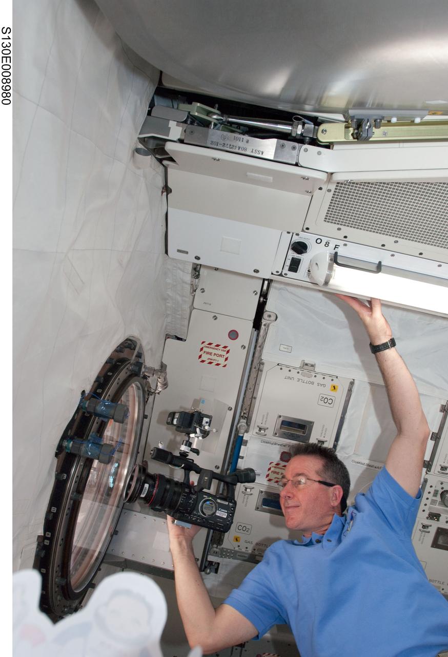 S130-E-008980 (16 Feb. 2010) --- NASA astronaut Stephen Robinson, STS-130 mission specialist, uses a High Definition Video (HDV) camera at a window in the Kibo laboratory of the International Space Station while space shuttle Endeavour remains docked with the station.