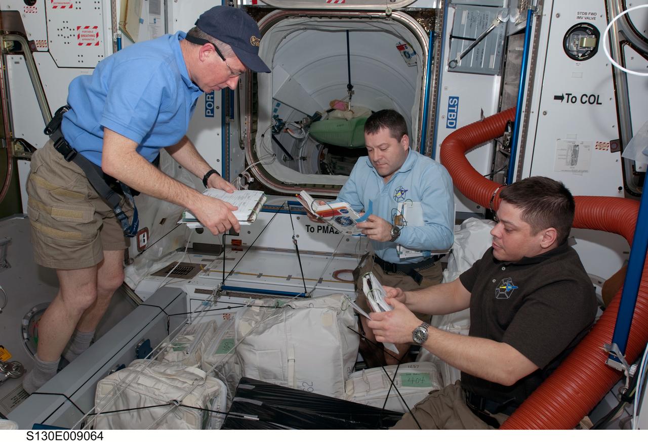S130-E-009064 (16 Feb. 2010) --- NASA astronauts Stephen Robinson (left), Nicholas Patrick and Robert Behnken, all STS-130 mission specialists, work in the Harmony node of the International Space Station while space shuttle Endeavour remains docked with the station.