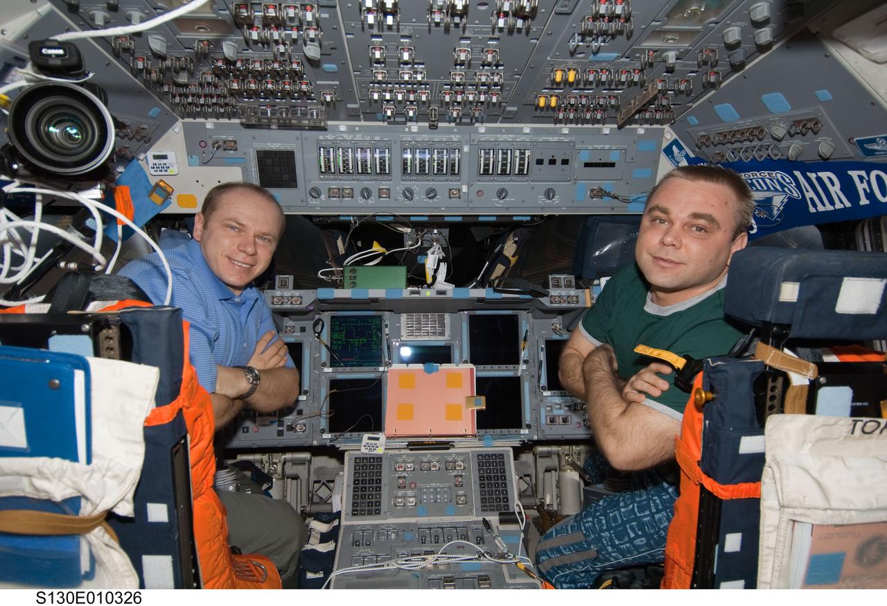 S130-E-010326 (18 Feb. 2010) --- Russian cosmonauts Oleg Kotov (left) and Maxim Suraev, both Expedition 22 flight engineers, pose for a photo on the flight deck of space shuttle Endeavour while docked with the International Space Station.