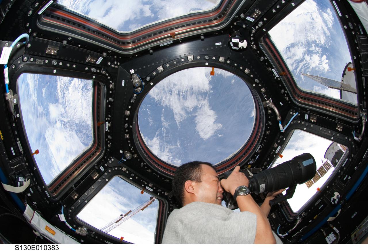 S130-E-010383 (19 Feb. 2010) --- Expedition 22 flight engineer Soichi Noguchi, Japan Aerospace Exploration Agency (JAXA) astronaut, takes photos through Window 5 in the Cupola aboard the International Space Station during Expedition 22 joint operations with the visiting STS-130 astronauts. One of the shuttle astronauts took this picture. Since the camera sports a large lens for this exercise, Noguchi is more than likely focusing in on a geographic site on Earth, as part of an ongoing Earth observations program. Photo credit: NASA