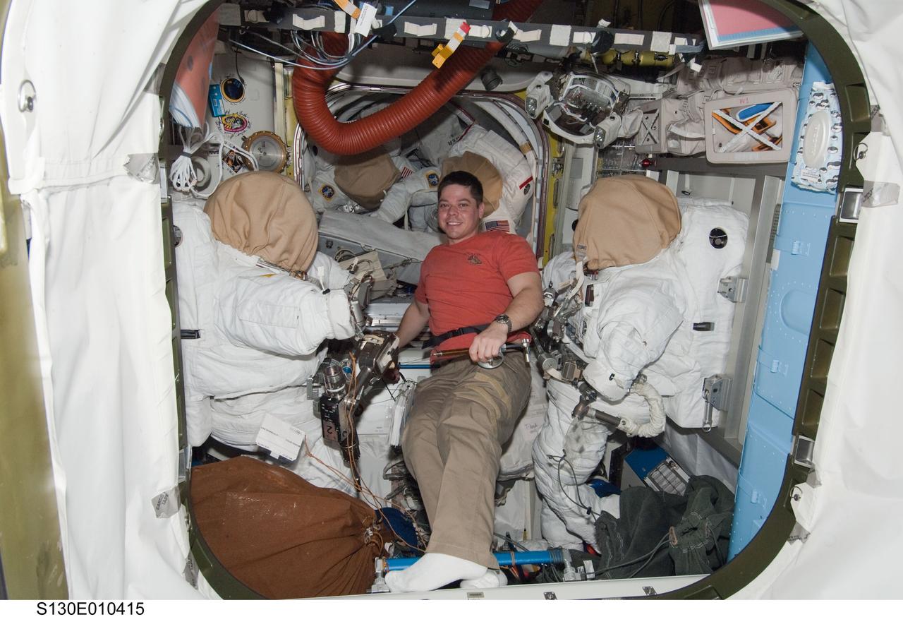 S130-E-010415 (18 Feb. 2010) --- NASA astronaut Robert Behnken, STS-130 mission specialist, works in the Quest airlock of the International Space Station while space shuttle Endeavour remains docked with the station.