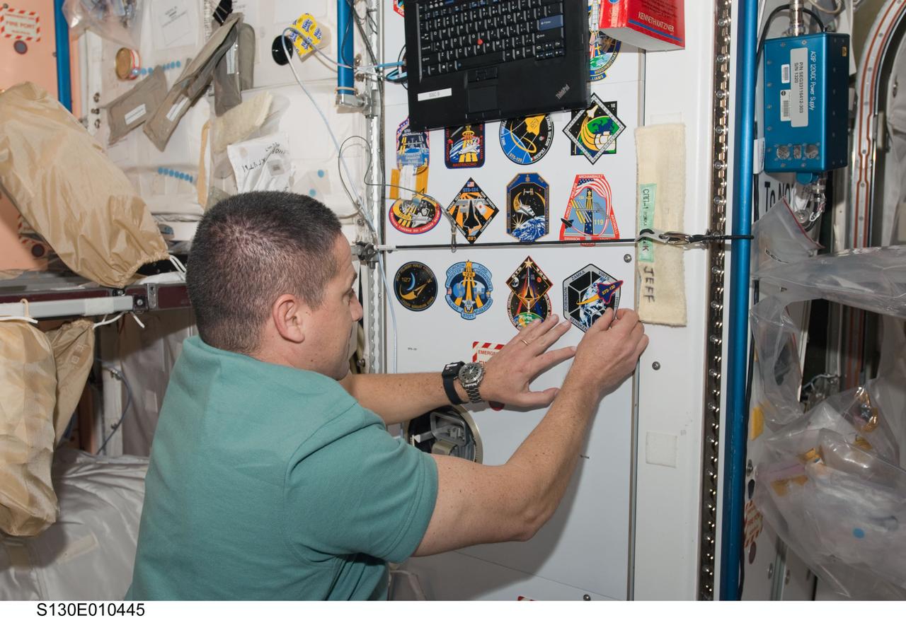 S130-E-010445 (18 Feb. 2010) --- NASA astronaut George Zamka, STS-130 commander, adds his crew's patch to the growing collection, in the Unity node, of insignias representing crews who have worked on the International Space Station.