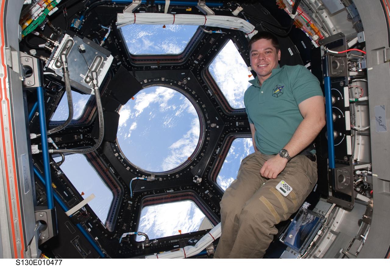 S130-E-010477 (19 Feb. 2010) --- NASA astronaut Robert Behnken, STS-130 mission specialist, poses for a photo near the windows in the Cupola of the International Space Station while space shuttle Endeavour remains docked with the station.