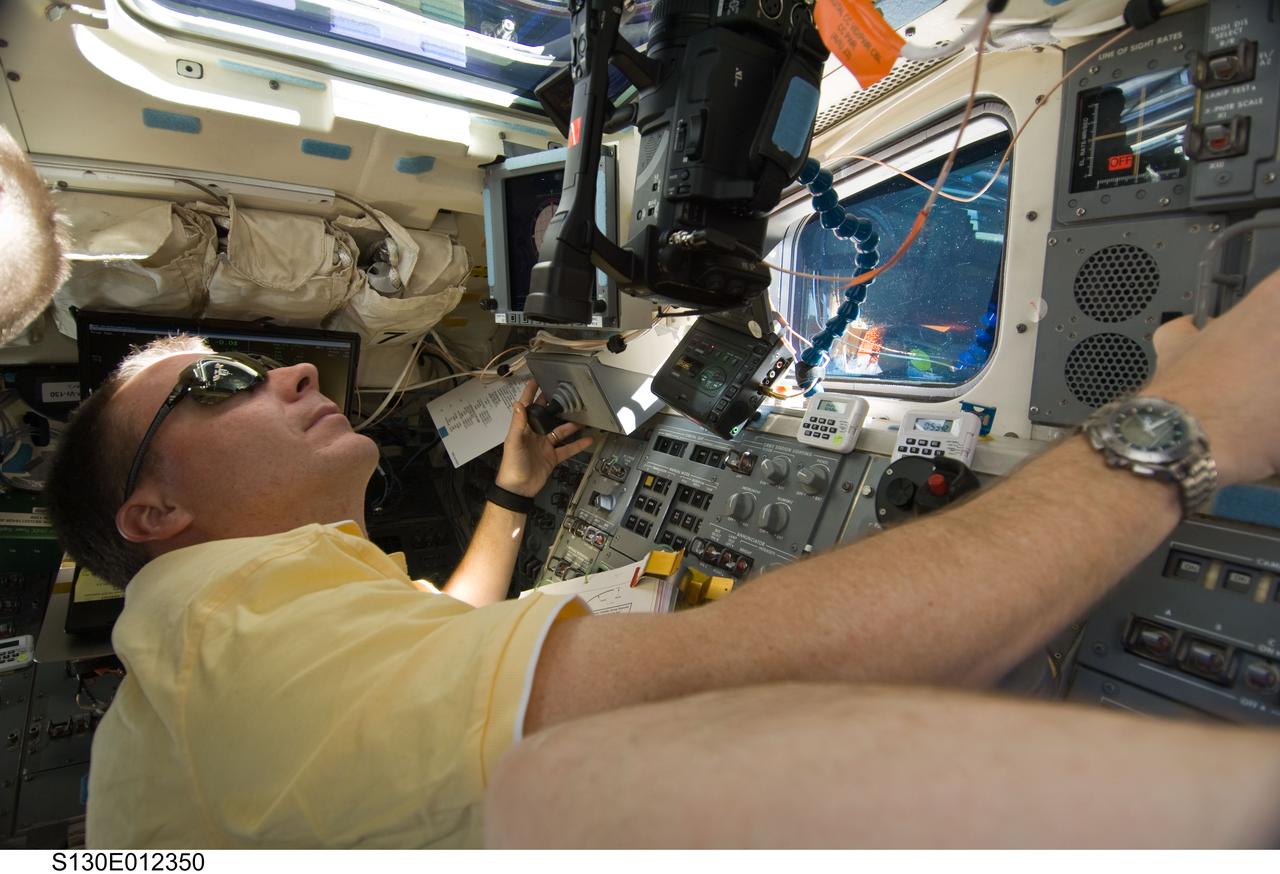 S130-E-012350 (19 Feb. 2010) --- NASA astronaut Terry Virts, STS-130 pilot, looks through an overhead window on the aft flight deck of space shuttle Endeavour during flight day 13 activities.