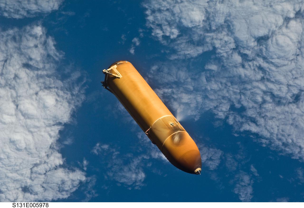 S131-E-005978 (5 April 2010) --- Backdropped by a blue and white part of Earth, the STS-131 external fuel tank (ET) begins its relative separation from the Space Shuttle Discovery following launch.