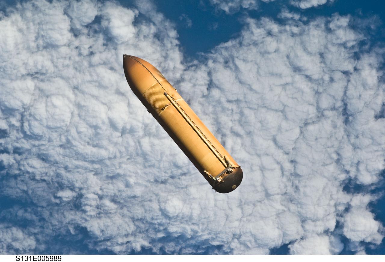 S131-E-005989 (5 April 2010) --- Backdropped by a blue and white part of Earth, the STS-131 external fuel tank (ET) begins its relative separation from the Space Shuttle Discovery following launch.